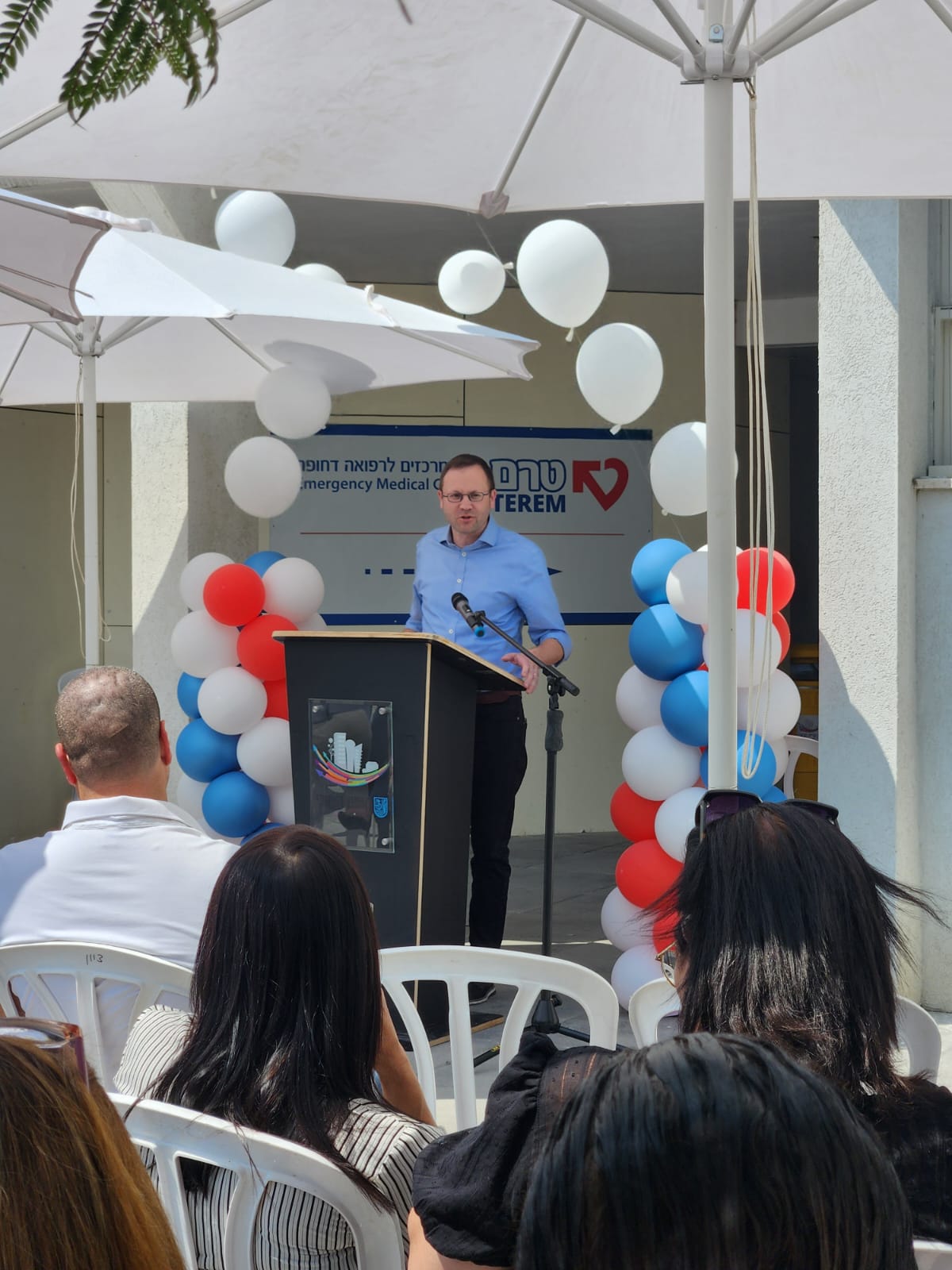 Speaker on Podium announcing the opening of a Terem clinic