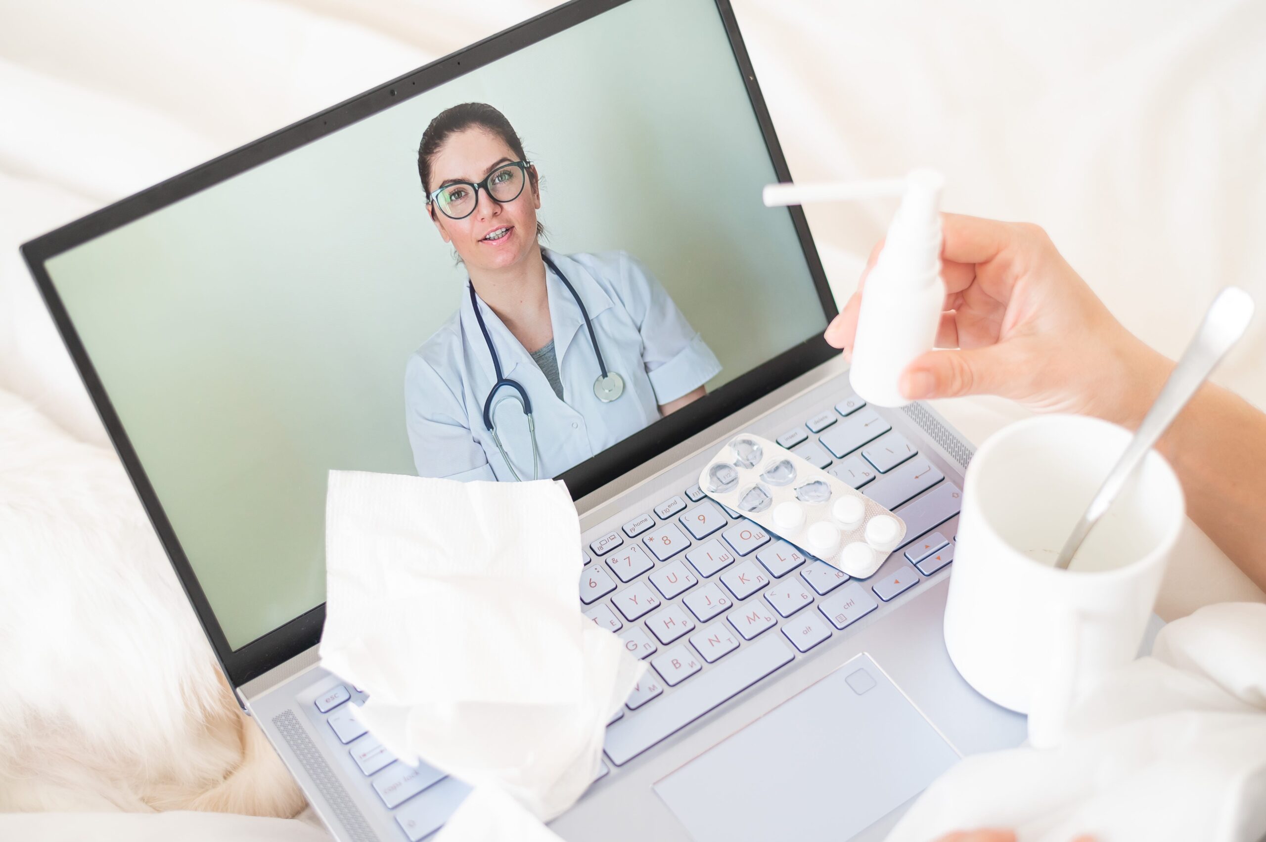 hands of a patient showing a medical professional medicine via a computer interface call